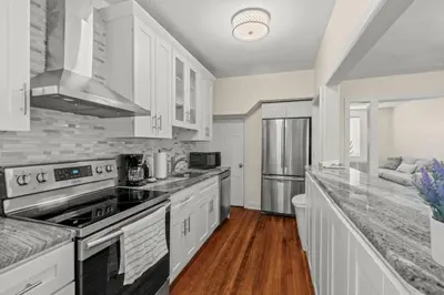 a kitchen with white cabinets and a stove top oven at Chestnut Hill 2BR Easy Parking in Philadelphia