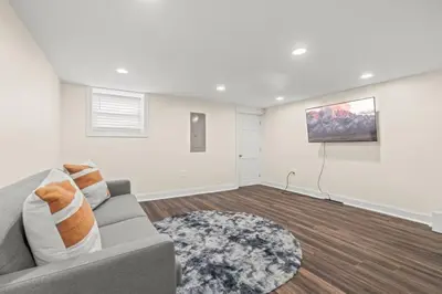 a living room with a couch and a painting on the wall at Chestnut Hill 2BR Easy Parking in Philadelphia