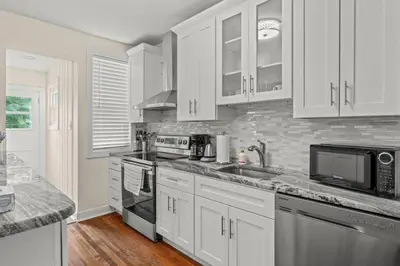 a kitchen with white cabinets and stainless steel appliances at Chestnut Hill 2BR Easy Parking in Philadelphia