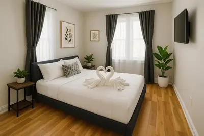 a bedroom with a bed with two white swans on it at 2 BR Apt|15 Min to NYC|Book Today in North Bergen