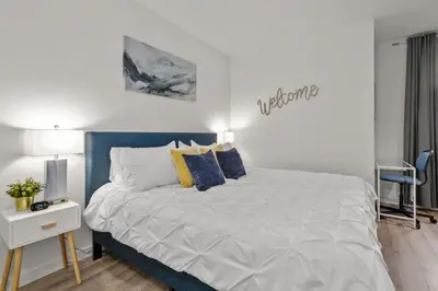 a bedroom with a bed with blue and yellow pillows at Luxury 1BR Apt-Pool RWJ-Rutgers StPeter-Free Parking - NYC316 in New Brunswick