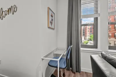 a living room with a blue chair and a couch at Luxury 1BR Apt-Pool RWJ-Rutgers StPeter-Free Parking - NYC316 in New Brunswick