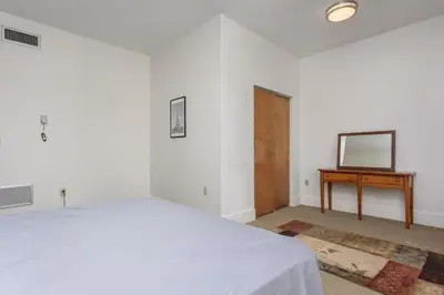 a white bedroom with a bed and a television at Capitol View Retreat - 2F Fast Wi-Fi Spacious in Harrisburg