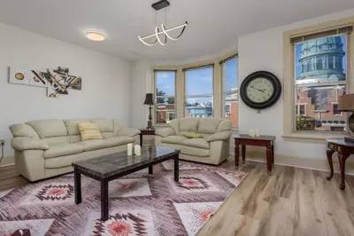 a living room with a couch and a table and a clock at Capitol View Retreat - 3F Fast Wi-Fi Cozy in Harrisburg