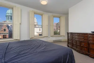 a bedroom with a bed and a dresser and windows at Capitol View Retreat - 3F Fast Wi-Fi Cozy in Harrisburg