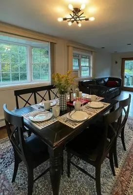 a dining room with a wooden table with chairs at Cozy Winter Chalet on 5 Acres - Fire Pit & Views in Livingston Manor