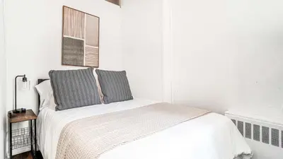 a white bedroom with a bed with two pillows at 2 Bedroom Apartment in Midtown Manhattan - Near NYC Icons! in New York