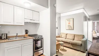 a kitchen and a living room with a couch at 2 Bedroom Apartment in Midtown Manhattan - Near NYC Icons! in New York