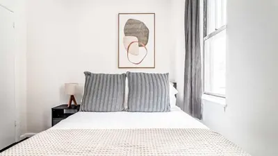 a white bedroom with a bed and a window at 2 Bedroom Apartment in Midtown Manhattan - Near NYC Icons! in New York