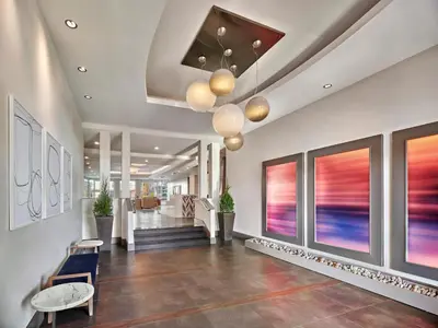 a lobby of a building with a staircase and artwork at AVE Union - Furnished Apartment, Union NJ in Union