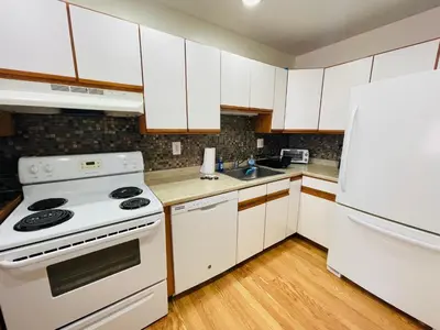 a kitchen with white appliances and a white refrigerator at Pet-Friendly 1BR Condo Free Parking, Discount! in Elkins Park