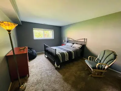 a bedroom with a bed and a chair and a lamp at Spacious 2BR2BA Monthly Discount in Elkins Park