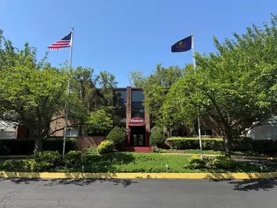 two american flags flying in front of a building at Spacious 2BR2BA Monthly Discount in Elkins Park