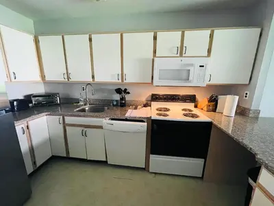 a kitchen with white cabinets and a stove and microwave at Spacious 2BR2BA Monthly Discount in Elkins Park