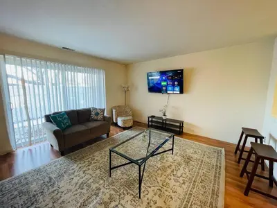 a living room with a couch and a tv on the wall at Bright & Spacious 2BR2BA Monthly Savings in Philadelphia
