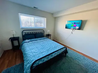 a bedroom with a bed and a tv on the wall at Bright & Spacious 2BR2BA Monthly Savings in Philadelphia