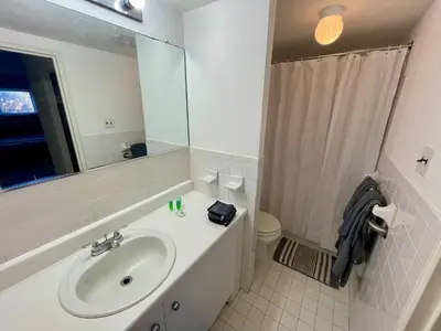 a bathroom with a sink and a toilet and a mirror at Bright & Spacious 2BR2BA Monthly Savings in Philadelphia