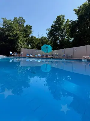 a swimming pool with chairs and an umbrella at Bright & Spacious 2BR2BA Monthly Savings in Philadelphia