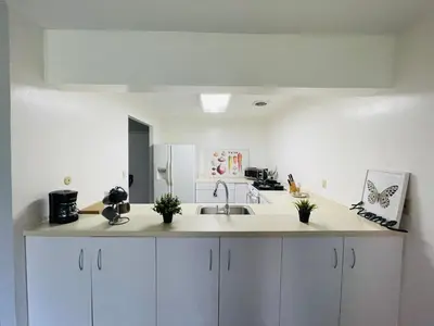 a kitchen with white cabinets and a sink at Wheelchair accessible & ground floor 2BR, 2BA in Elkins Park