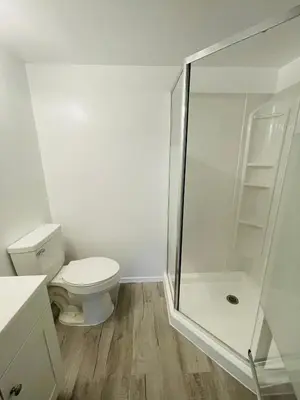 a bathroom with a toilet and a glass shower at Wheelchair accessible & ground floor 2BR, 2BA in Elkins Park