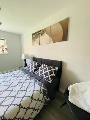 a bedroom with a bed with a black and white comforter at Wheelchair accessible & ground floor 2BR, 2BA in Elkins Park