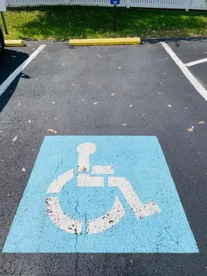 a blue handicapped sign in a parking lot at Wheelchair accessible & ground floor 2BR, 2BA in Elkins Park