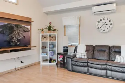 a living room with a couch and a clock on the wall at Mansion in the Hills with Pool in Monroe