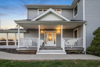 a house with a porch with two chairs on it at Mansion in the Hills with Pool in Monroe