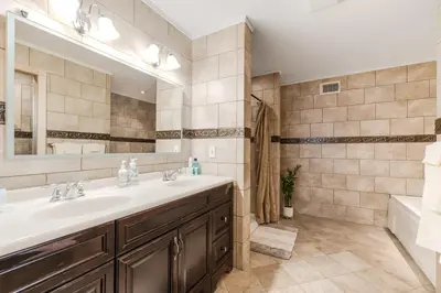 a bathroom with a sink and a mirror and a tub at Mansion in the Hills with Pool in Monroe