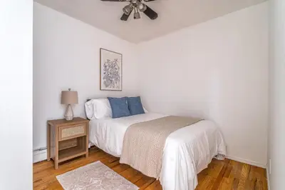 a white bedroom with a bed and a ceiling fan at Spacious 3BR Apartment in Kips Bay - Central Manhattan Location! in New York