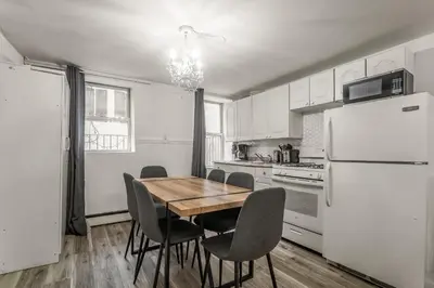 a kitchen with a table and chairs and a refrigerator at Spacious 3BR Apartment in Kips Bay - Central Manhattan Location! in New York