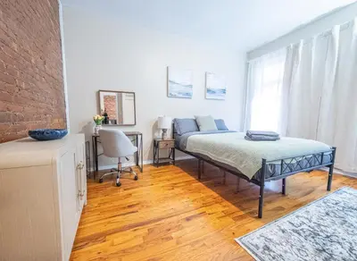 a bedroom with a bed and a desk and a couch at Spacious 3BR Near Columbia Uni & Riverside Park in New York