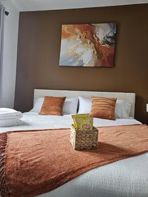 a bedroom with two beds and a painting on the wall at 20 minutes to Central Park Manhattan New York City 16 mins Metlife stadium in West New York
