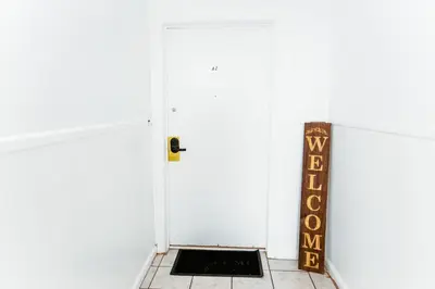 a white door with a welcome sign next to it at Fast transit to Manhattan with Parking on premises in North Bergen