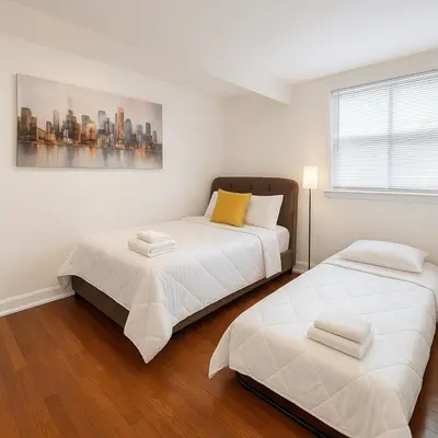 a bedroom with two beds and a painting on the wall at Fast transit to Manhattan with Parking on premises in North Bergen