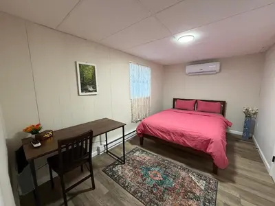 a bedroom with a bed and a desk with a pink bedspread at Evergreen Escapes 4 BR with Game Room, Firepit near Kalahari and Camelback in Long Pond
