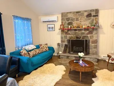 a living room with a blue couch and a fireplace at Evergreen Escapes 4 BR with Game Room, Firepit near Kalahari and Camelback in Long Pond