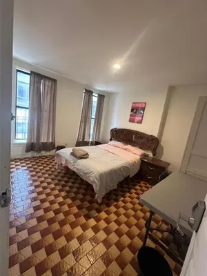 a bedroom with a bed and a table in it at Al Demashqi in New York