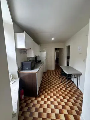 a small kitchen with a counter and a table at Al Demashqi in New York