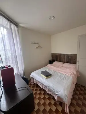a bedroom with a bed and a chair and a window at Al Demashqi in New York
