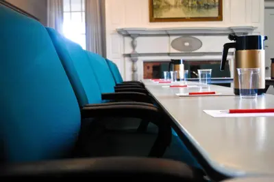 a conference room with a table with blue chairs at Rutgers University Inn and Conference Center in New Brunswick