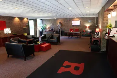 a waiting room with chairs and tables and a tv at Rutgers University Inn and Conference Center in New Brunswick