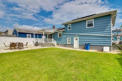 a blue house with a lawn in front of it at The Vault Your Fun Secured in Hillside