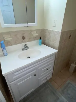 a bathroom with a white sink and a mirror at Cozy 2 Bedrooms 1and half Bathrooms Near Prudential with Parking Entire Apartment in Newark