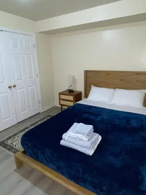 a bedroom with a bed with a blue blanket and a door at Cozy 2 Bedrooms 1and half Bathrooms Near Prudential with Parking Entire Apartment in Newark