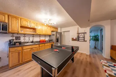 a kitchen with a ping pong table in the middle at 5BR 3BTH House, Steps to Bars, Dining, NYC Access with GameRm, Backyard with BBQ and Parking in Jersey City
