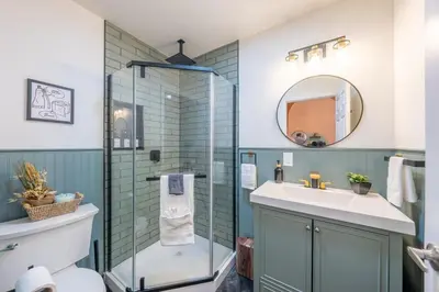 a bathroom with a glass shower and a sink at 5BR 3BTH House, Steps to Bars, Dining, NYC Access with GameRm, Backyard with BBQ and Parking in Jersey City