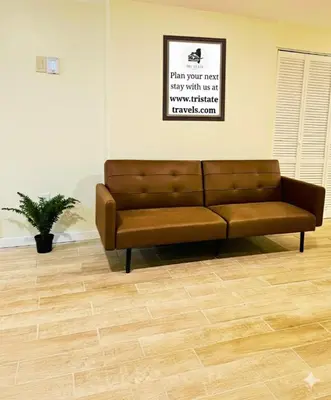 a brown couch sitting in a living room at Cozy Riverside View House in Montague