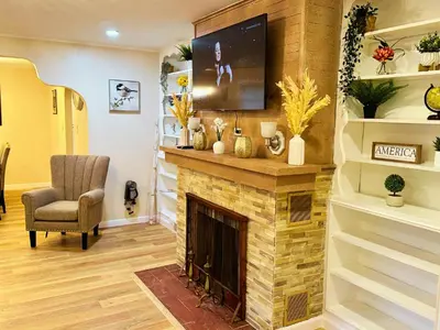 a living room with a fireplace with a flat screen tv at Cozy Riverside View House in Montague