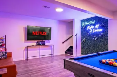 a living room with a pool table and a flat screen tv at Chalet with Hot Tub, Game, Movie Room, Lake and Pool Access in Gouldsboro